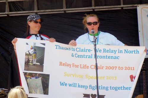 Tonya Eastman and Lesley Merrigan unfurl the 2015 Relay Banner in honour of Claire Macfarlane, who passed away May 20.